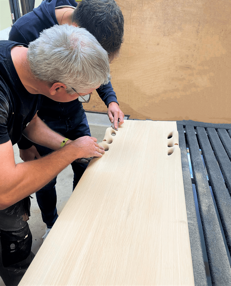 Collaborateurs Chastagner travaillant ensemble sur une pièce en bois en atelier