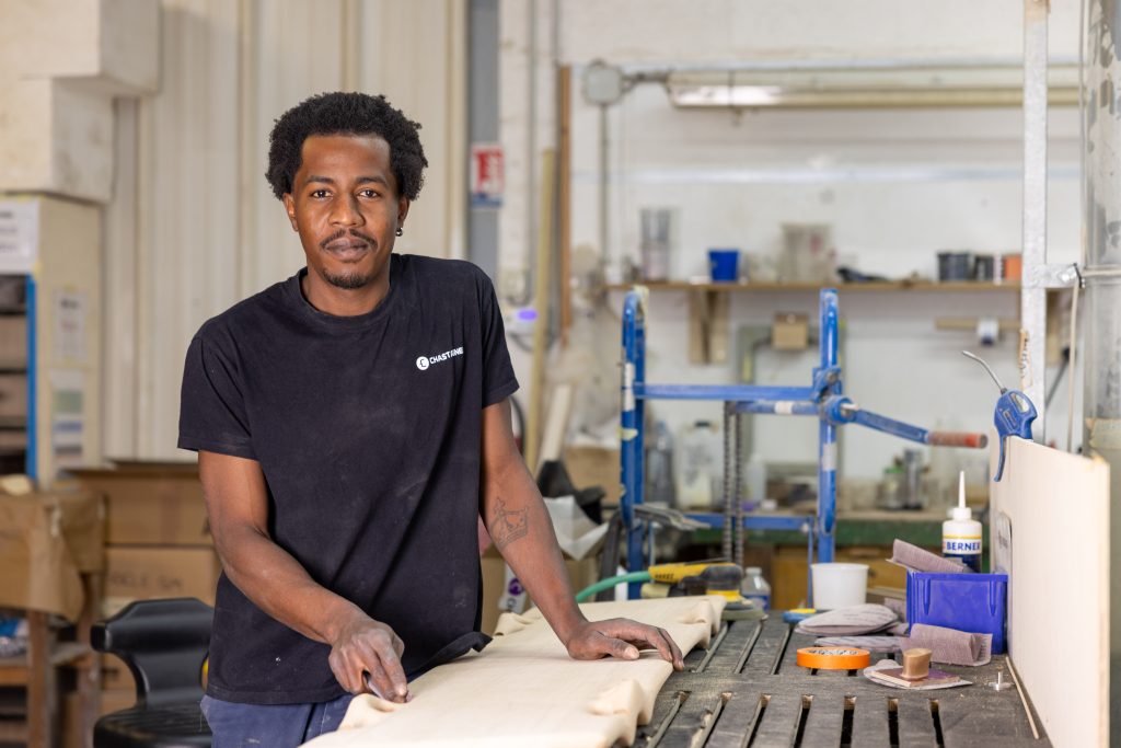 Ébéniste Chastagner travaillant le bois dans un atelier de fabrication haut de gamme.