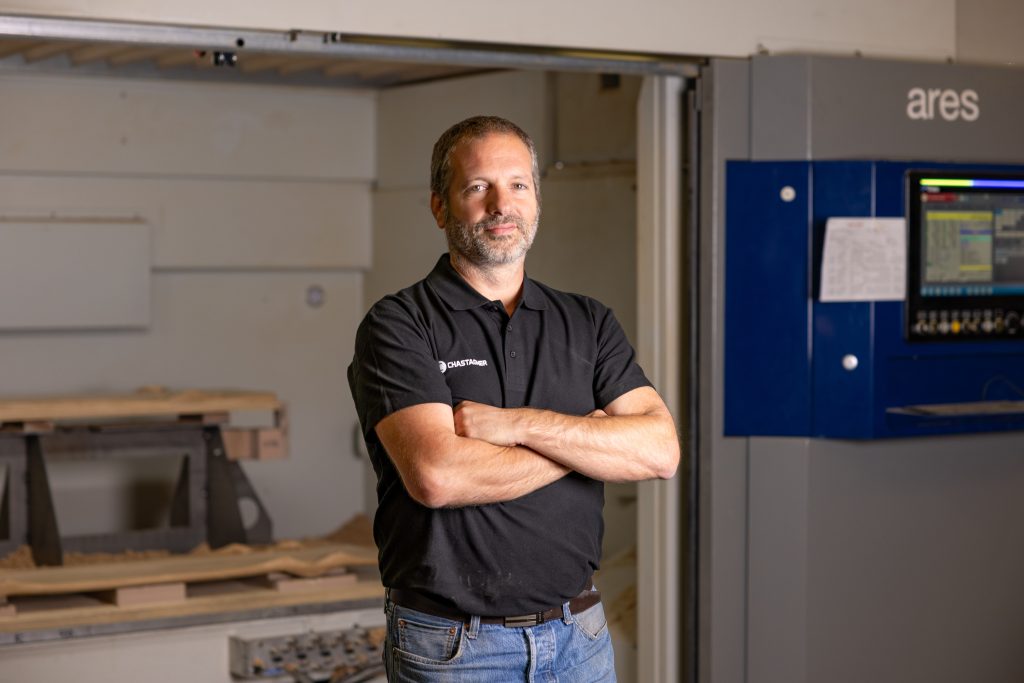 Technicien usinage CNC bois devant un centre d’usinage dans les ateliers Chastagner.