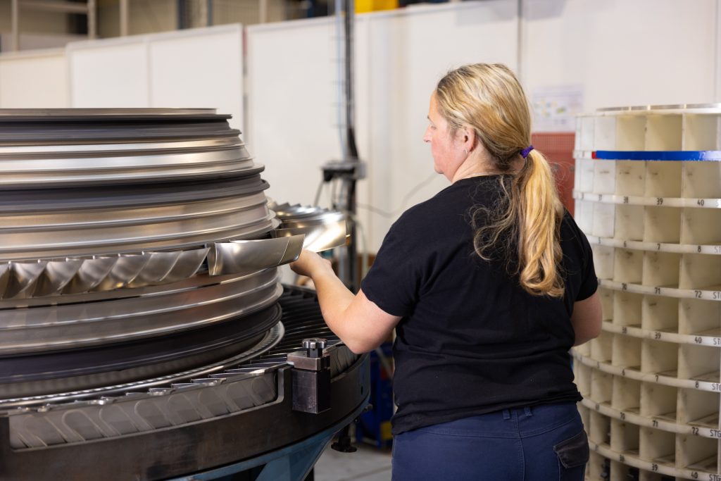 Collaboratrice Chastagner travaillant devant un moteur aéronautique, illustrant l’assemblage et le contrôle de sous-ensembles techniques pour l’aéronautique.