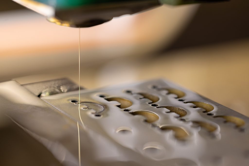 Découpe par électro-érosion à fil sur une pièce technique, illustrant la précision industrielle et le savoir-faire Chastagner.