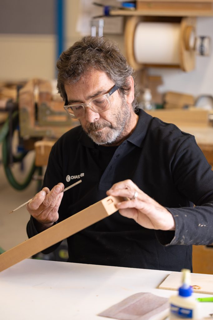 Collaborateur Chastagner travaillant une pièce en atelier, illustrant le savoir-faire artisanal et la finition de produits haut de gamme.