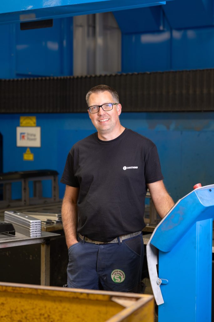 Technicien Chastagner devant une machine de découpe laser pour la tôlerie.